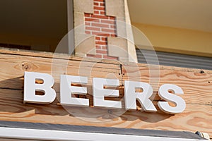 beers bar sign text on pub in city street storefront facade building