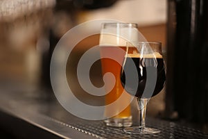 Beers in glasses on bar counter, space for text