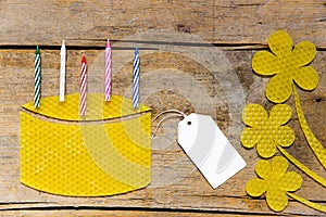 Beeswax, cake with candles and flowers on wooden table, empty si