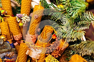 Beeswax candles decorated in Christmas style and a twig tree. Design for the new year.