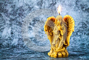 Beeswax praying angel candle on stone background