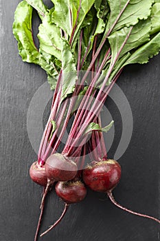 Beet, beetroot bunch on black stone background. Copy space