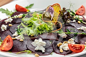 Beet carpaccio with feta, arugula and olive oil. italian cuisine. Food recipe background. Close up