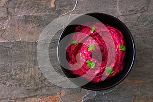 Beet hummus above view on a dark background