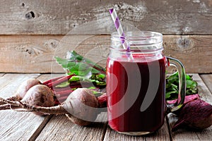 Beet juice in a mason jar with beets over rustic wood