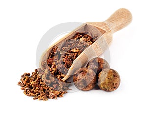 Beet propolis granules in a wooden spoon are isolated on a white background. Natural antibiotic. Beekeeping product