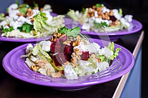 Beet salad with goat cheese, walnuts, greens and herbs and olive oil.