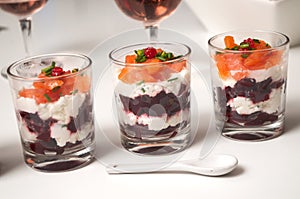 Beet and salmon appetizers in little glasses on white background