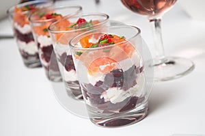 Beet and salmon appetizers in little glasses on white background