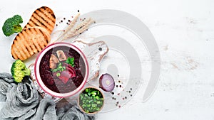 Beetroot cream soup in a bowl, with toast bread. Dietary food. Top view.