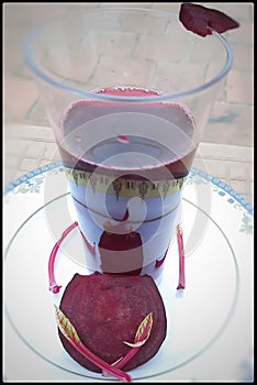 Beetroot juice in glass with beetroot slices in white plate to blemishes black spots acne or pimples photo