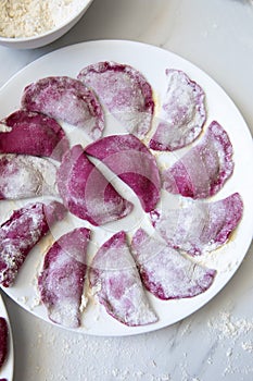 Beetroot Pasta ravioli in the making against white background. Top view, flat lay, copy space