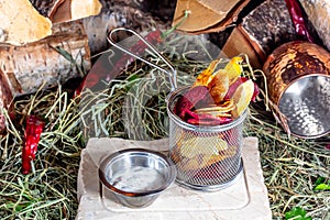 beetroot and potato chips in a metal basket on the background of the fire