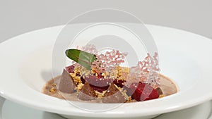 Beetroot salad. Salad with roasted beetroot, spinach, soft goat cheese and seeds in light plate over grey concrete