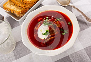 Beetroot soup with beef served with sour cream and greens