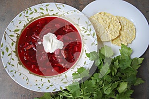 Beetroot soup in plate with parsley and corn crackers.