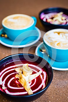 Beetroot Vegan Cold Soup and Cappuccino in Big Blue Cups in Modern Vegan Cafe