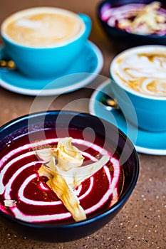 Beetroot Vegan Cold Soup and Cappuccino in Big Blue Cups in Modern Vegan Cafe