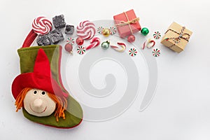 Befana sock with sweet coal and candy on white background. Italian Epiphany day tradition.