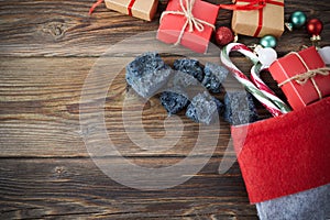 The Befana sock with sweet coal and candy on wooden background. Italian Epiphany day tradition.