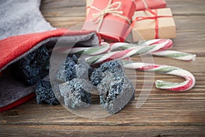 The Befana sock with sweet coal and candy on wooden background. Italian Epiphany day tradition.