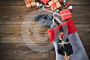 The Befana with sweet coal and candy on wooden background. Italian Epiphany day tradition.