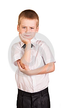 Befuddled cute schoolboy isolated on white.