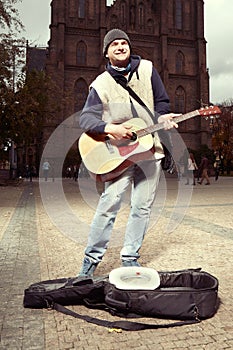 Beggar with guitar trying to earn money on public