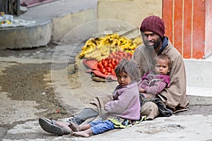 Beggar man with children begging on the street in Leh, Ladakh. India