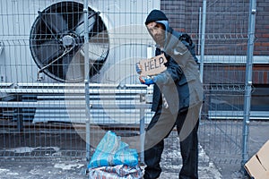 Beggar man and help sign on city street