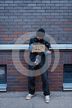 Beggar man and help sign on city street