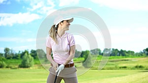 Beginner female golf player holding club and smiling, rejoicing shot, victory