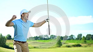 Beginner golf player with club in hand rejoicing successful shot, luck and sport