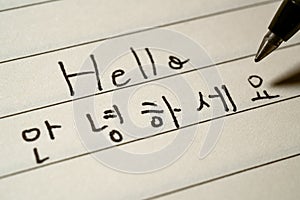 Beginner Korean language learner writing Hello word in Korean characters macro shot photo