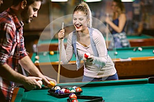 Beginning billiard game - man and woman flirting while playing snooker