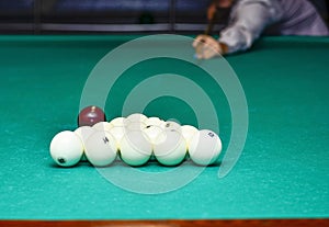 The beginning of the billiard party. The moment the ball hits the pyramid on the background of the player