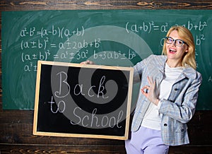 Beginning of new school season. Woman teacher holds blackboard inscription back to school. Are you ready to study. Lady