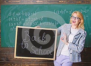 Beginning of new school season. Woman teacher holds blackboard inscription back to school. Are you ready to study. Lady