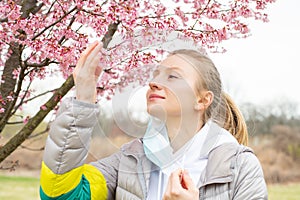 Beginning of Spring. Beautiful woman enjoying nature blooming tree