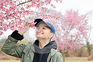 Beginning of Spring. Beautiful woman enjoying nature blooming tree