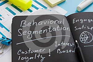 Behavioral segmentation sign with marks on the dark notepad.