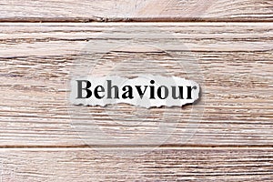 Behaviour of the word on paper. concept. Words of behaviour on a wooden background