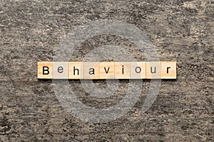 BEHAVIOUR word written on wood block. BEHAVIOUR text on cement table for your desing, concept