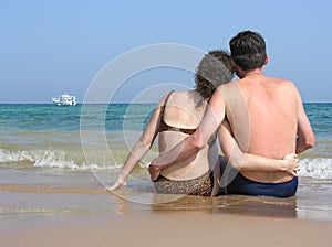 Behind couple sit on beach