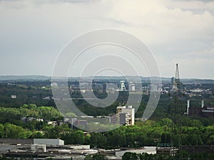 Behind extremely blurred foreground high-voltage lines in green environment in blur are residential and office buildings