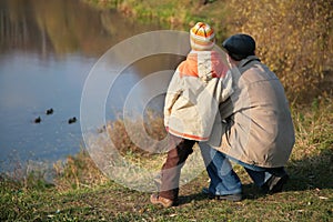 Behind grandfather with grandson look on ducks