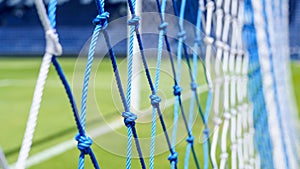 Behind the ropes of the outdoor soccer field goal net, football goal background