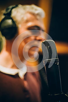 Behind scene. Famous alternative male singer practice singing on microphone