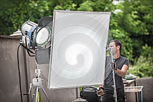 Behind the scene. Filmmaking lighting technician adjusting and setup lights