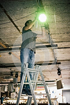 Behind the scene. Lighting technician electric engineer adjusting stage lights